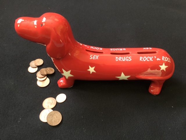 image shows daschund shaped money box with coins